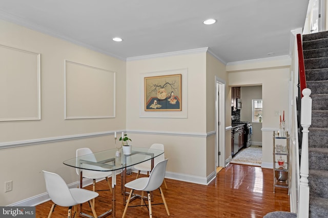 dining room with crown molding, stairway, and wood finished floors