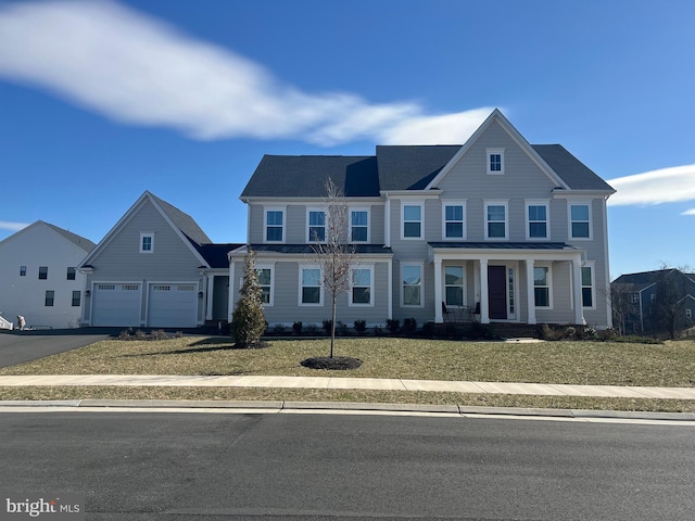 view of front of home featuring a standing seam roof, driveway, a porch, and a front yard