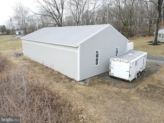 view of home's exterior with metal roof, a pole building, and an outdoor structure