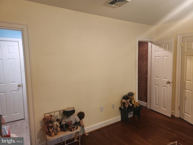 misc room featuring visible vents, baseboards, and wood finished floors