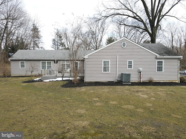 back of house featuring a yard, roof with shingles, central AC unit, and a patio