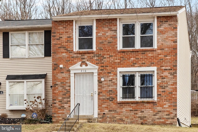 townhome / multi-family property featuring entry steps and brick siding