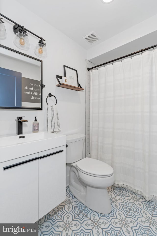 full bathroom with tile patterned flooring, visible vents, vanity, and toilet