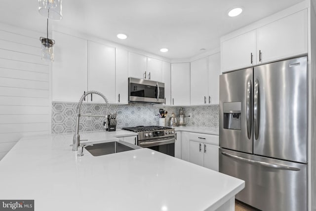 kitchen featuring a sink, stainless steel appliances, backsplash, and light countertops