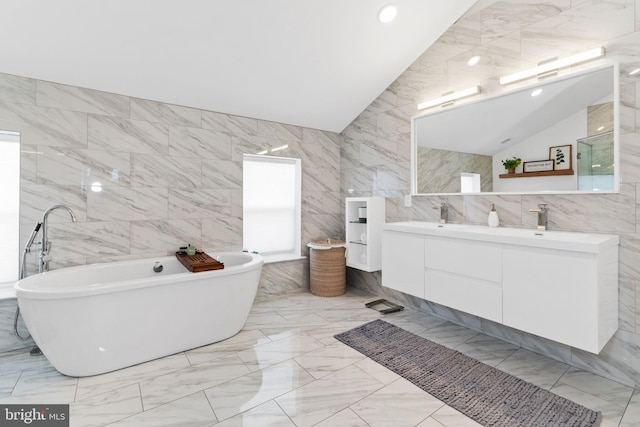 full bathroom featuring lofted ceiling, marble finish floor, and tile walls