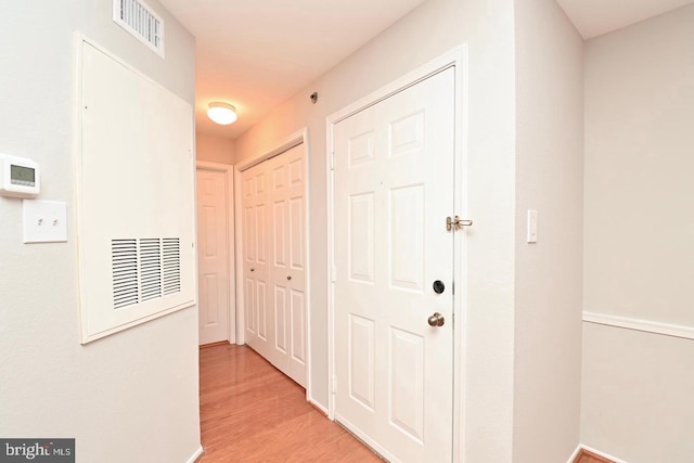 hall featuring visible vents and light wood-style floors