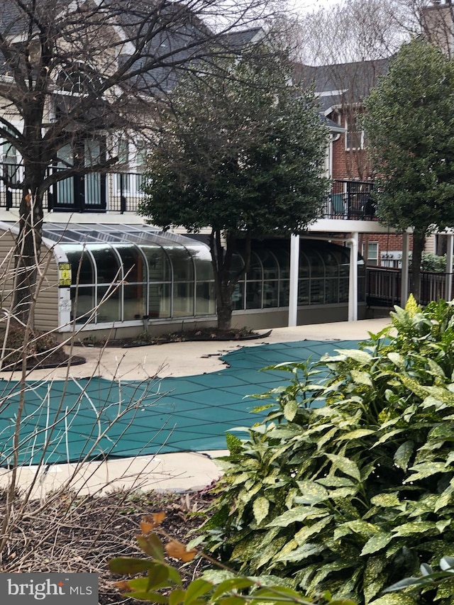 view of pool with a covered pool, a patio, and a sunroom