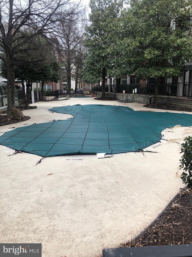 community pool featuring a patio area and fence