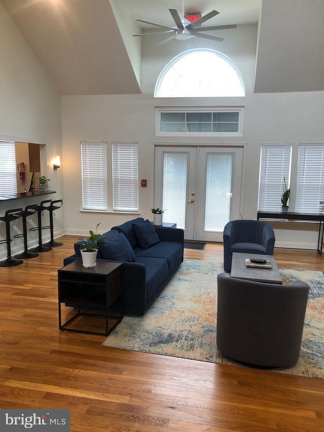 living room with french doors, high vaulted ceiling, ceiling fan, and wood finished floors