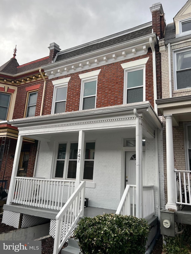 view of home's exterior with a porch and brick siding