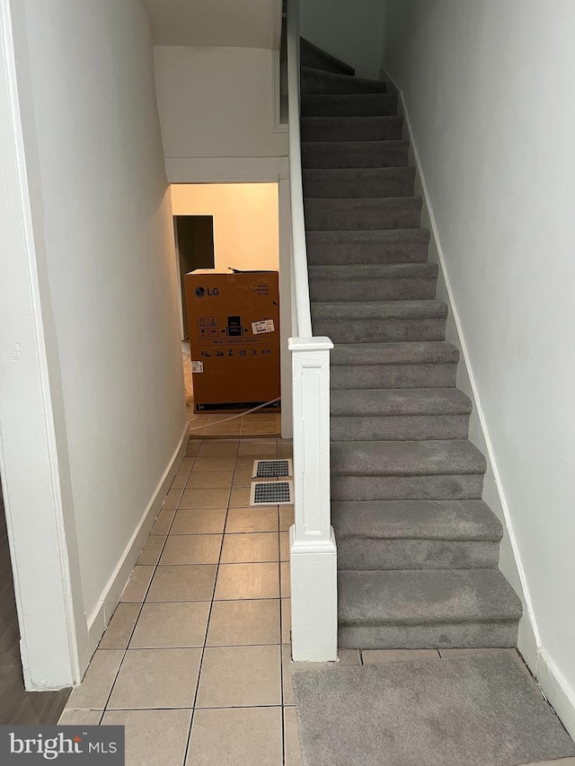 staircase featuring tile patterned flooring and baseboards