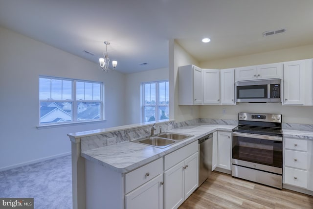 4902 E Pebble Ln Unit E, Milford, DE 19963 - kitchen featuring visible vents, a sink, stainless steel appliances, a peninsula, and light countertops