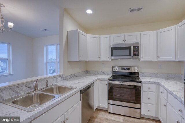 4902 E Pebble Ln Unit E, Milford, DE 19963 - kitchen with light wood-style flooring, a sink, recessed lighting, appliances with stainless steel finishes, and white cabinets