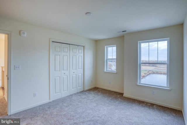 4902 E Pebble Ln Unit E, Milford, DE 19963 - unfurnished bedroom featuring a closet, visible vents, baseboards, and carpet