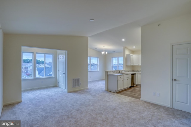 4902 E Pebble Ln Unit E, Milford, DE 19963 - interior space featuring baseboards, visible vents, lofted ceiling, a sink, and light carpet