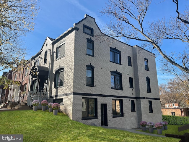 exterior space with a front yard and brick siding