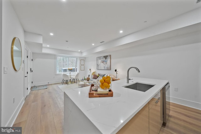 kitchen featuring light wood-style floors, a large island, a sink, and recessed lighting