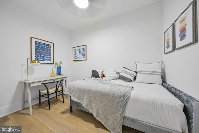 bedroom with baseboards and wood finished floors