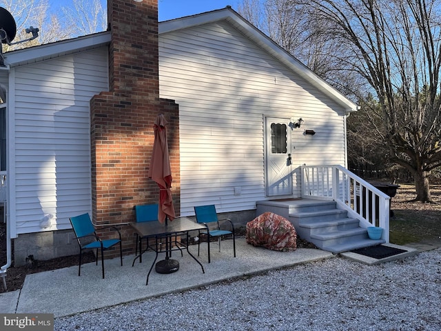 rear view of house featuring a chimney and a patio