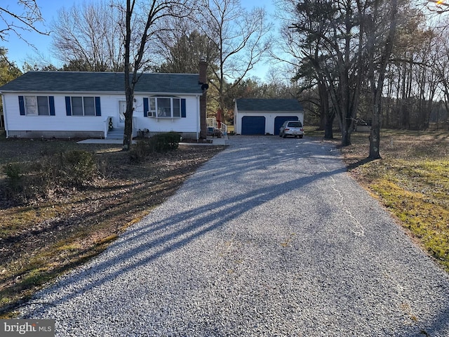 ranch-style home featuring a garage and an outbuilding