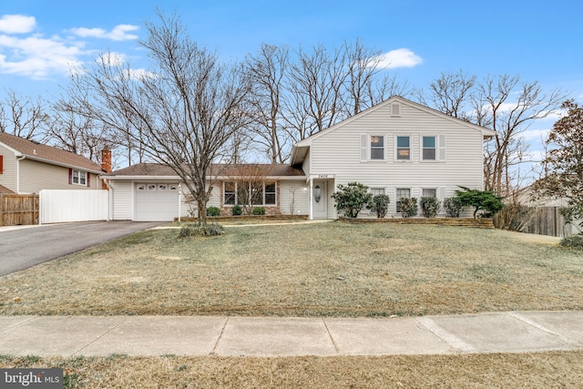 traditional home with a garage, a front yard, driveway, and fence