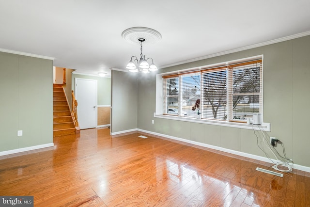 unfurnished room featuring stairs, light wood-style flooring, and crown molding