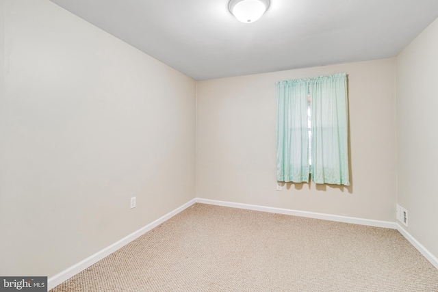 unfurnished room with baseboards, carpet floors, and visible vents