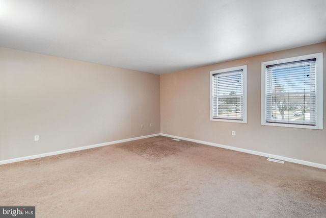 spare room with baseboards and carpet floors