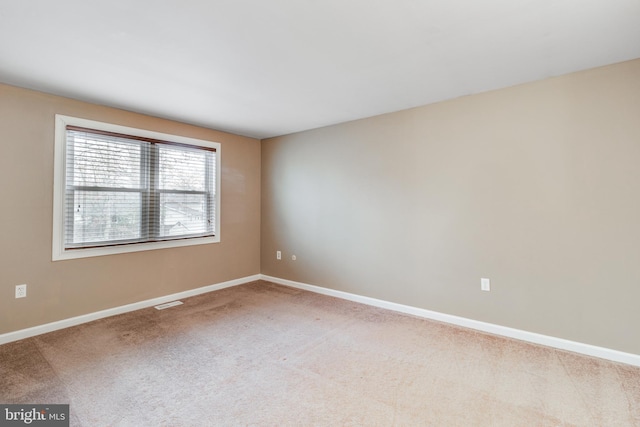 carpeted empty room with baseboards