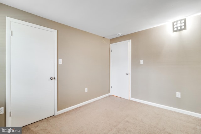 carpeted spare room featuring baseboards