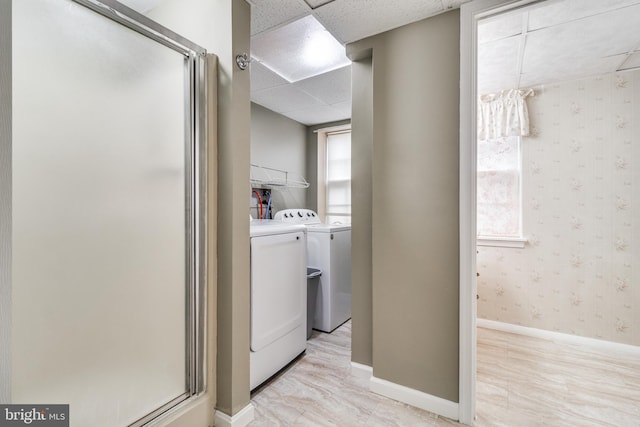 laundry area with wallpapered walls, baseboards, laundry area, and washing machine and clothes dryer