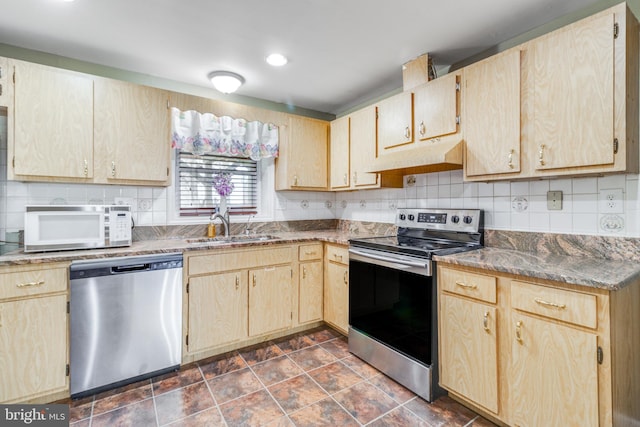 kitchen featuring light brown cabinets, a sink, decorative backsplash, stainless steel appliances, and under cabinet range hood