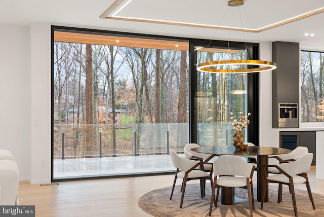 dining space with a wall of windows and wood finished floors