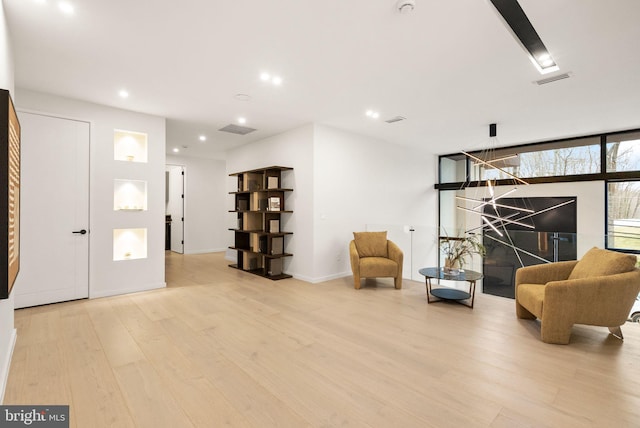 living area with recessed lighting, baseboards, visible vents, and light wood finished floors