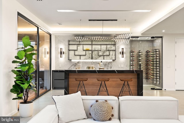 bar featuring baseboards and indoor wet bar