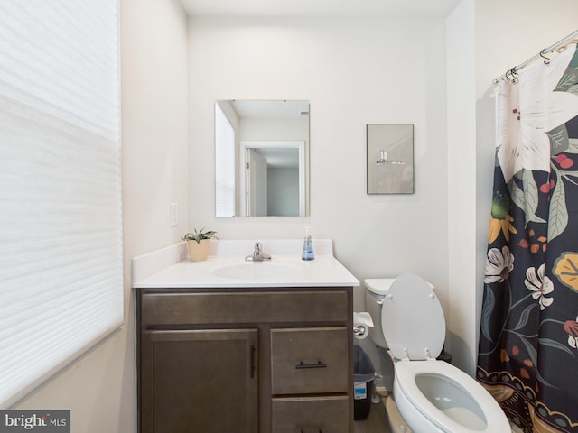 bathroom with a shower with shower curtain, vanity, and toilet