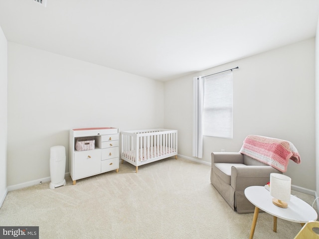 bedroom featuring carpet flooring, a crib, and baseboards