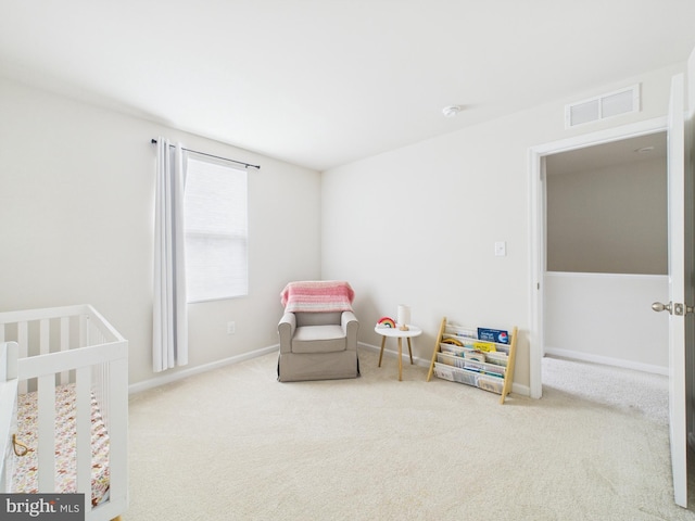 bedroom with a crib, carpet floors, baseboards, and visible vents