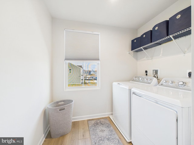 laundry area featuring laundry area, baseboards, light wood finished floors, and independent washer and dryer