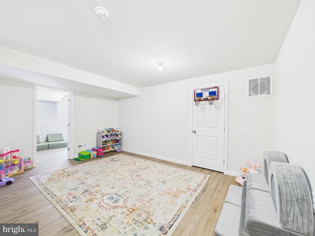 game room with light wood-type flooring, visible vents, and baseboards