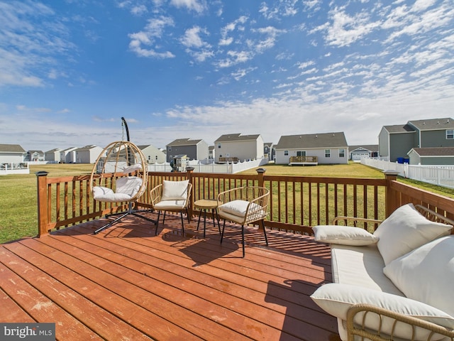 wooden deck featuring a residential view, a lawn, and fence