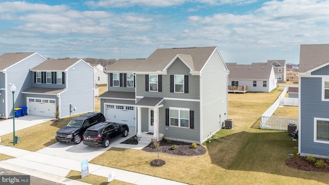 traditional-style house with cooling unit, concrete driveway, a residential view, and an attached garage