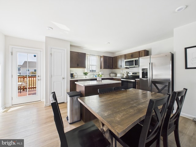 dining area with light wood finished floors and baseboards