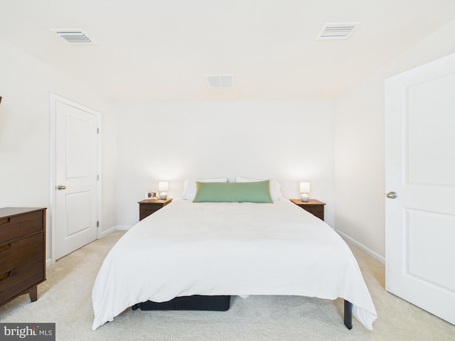 bedroom with baseboards, visible vents, and light colored carpet