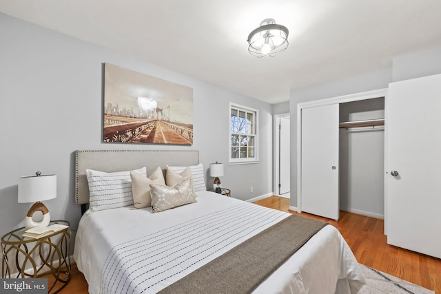 bedroom featuring a closet, baseboards, and wood finished floors