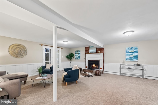 living room with french doors, carpet, a fireplace, wainscoting, and baseboard heating