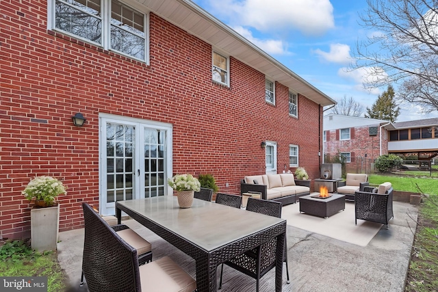 view of patio / terrace featuring an outdoor living space with a fire pit and french doors