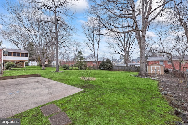 view of yard with a storage shed, an outbuilding, and a fenced backyard