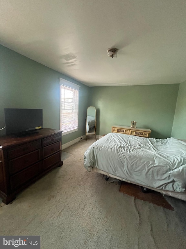 bedroom featuring baseboards and light colored carpet