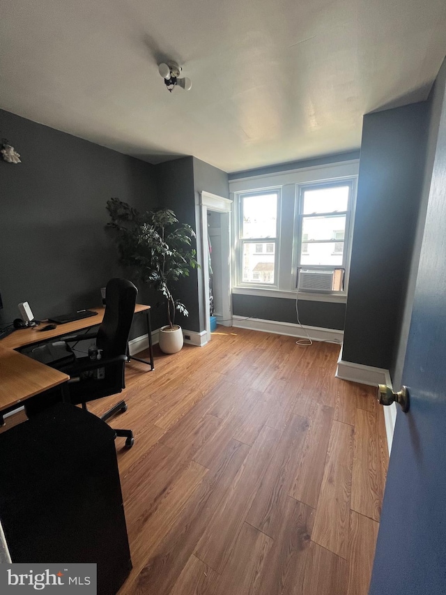 office area featuring cooling unit, baseboards, and wood finished floors